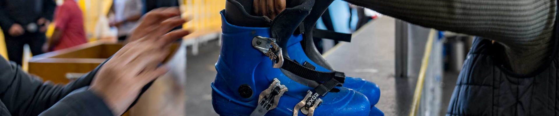 Un agent de la patinoire remet une paire de patins à un visiteur