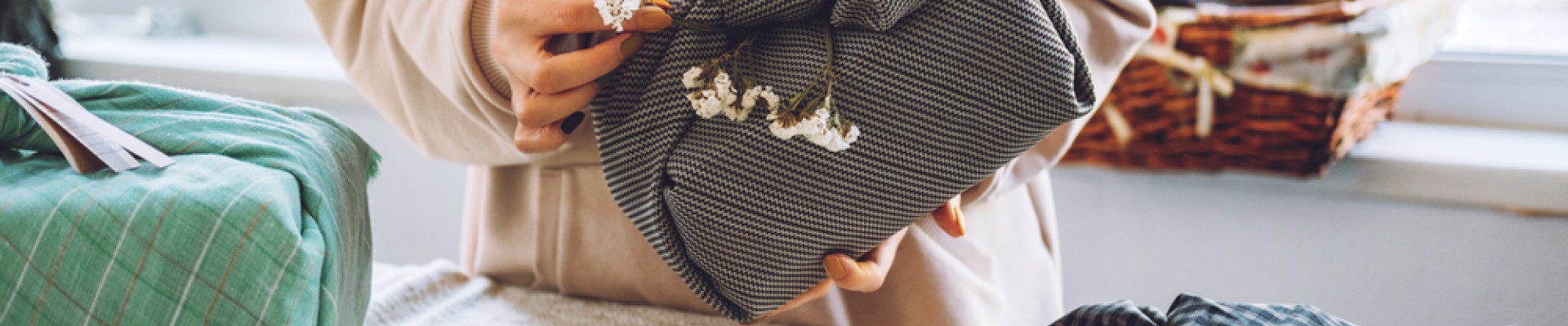 cadeau emballé avec du tissu dans les mains d'une femme