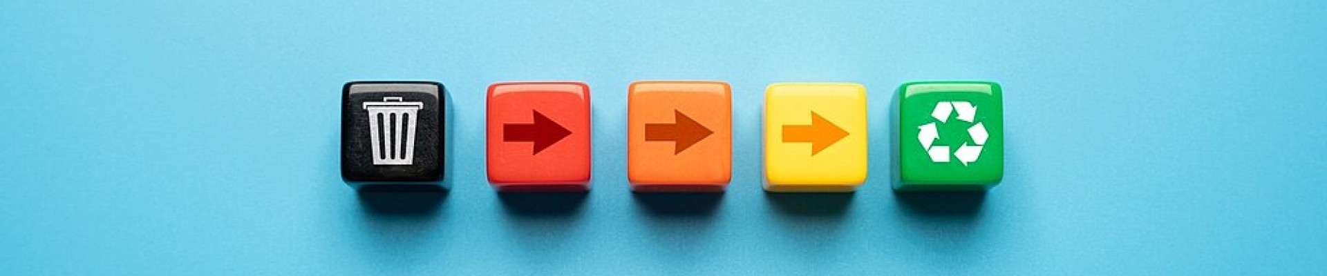 5 cubes alignés : le 1er noir avec un logo poubelle, les 3 suivants avec des flèches et un dégradé du rouge au jaune en passant par l'orange, et pour finir 1 cube vert avec logo recyclage