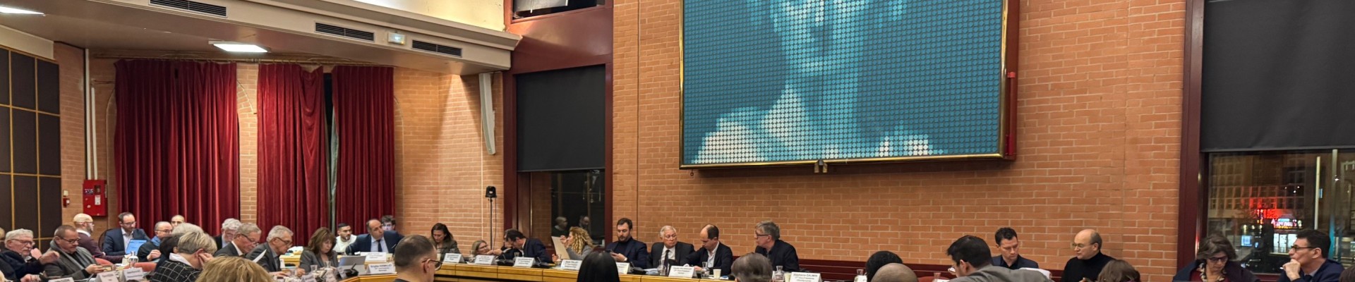 La grande salle des assemblées de Vitry avec une Marianne en fond et des élus assis en train de délibérer