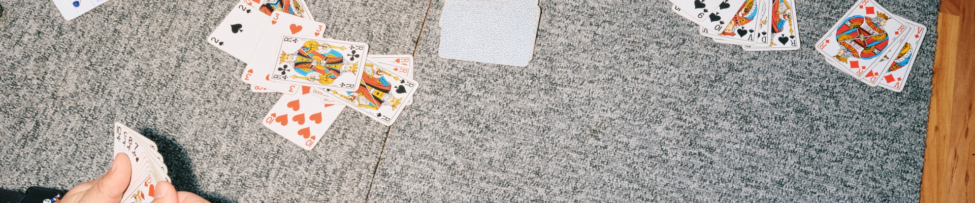 Table de café où quatre personnes jouent aux cartes