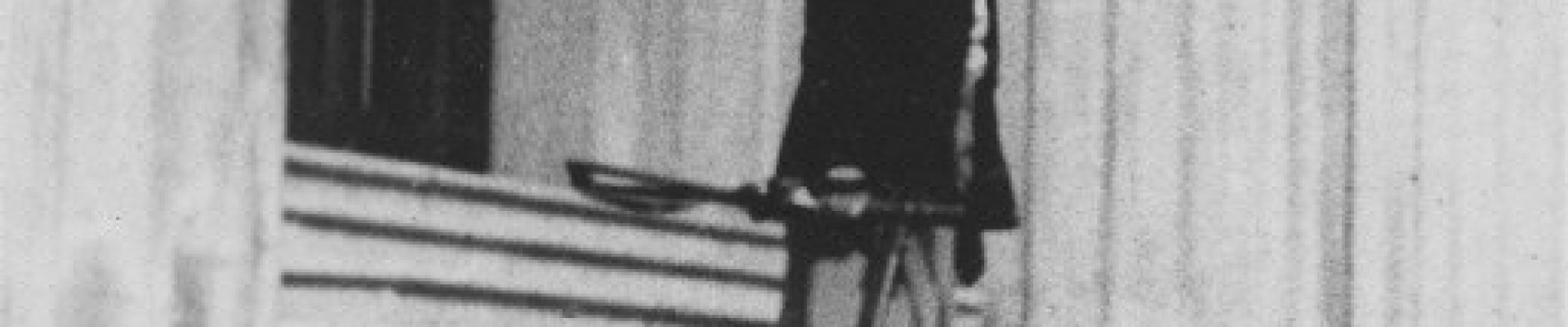 Photographie en noir et blanc d'une femme se tenant debout sur des escaliers