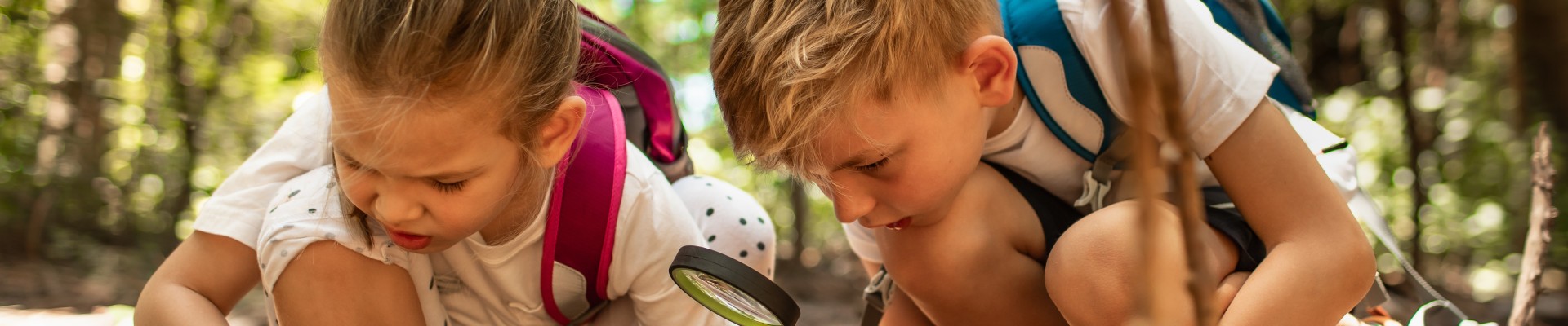 enfants qui observent le sol avec une loupe
