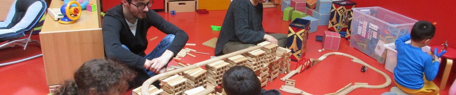 Enfants et deux adulates jouant à un jeu de construction