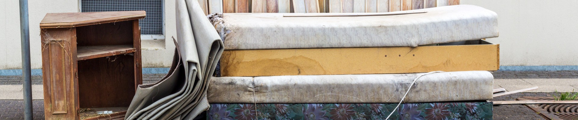Matelas et morceaux de meubles sur le trottoir