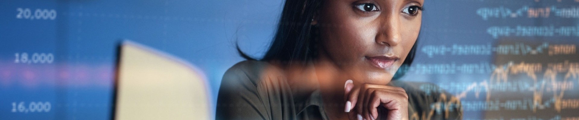 une femme regarde un écran d'ordinateur, dans un reflet de lignes de code