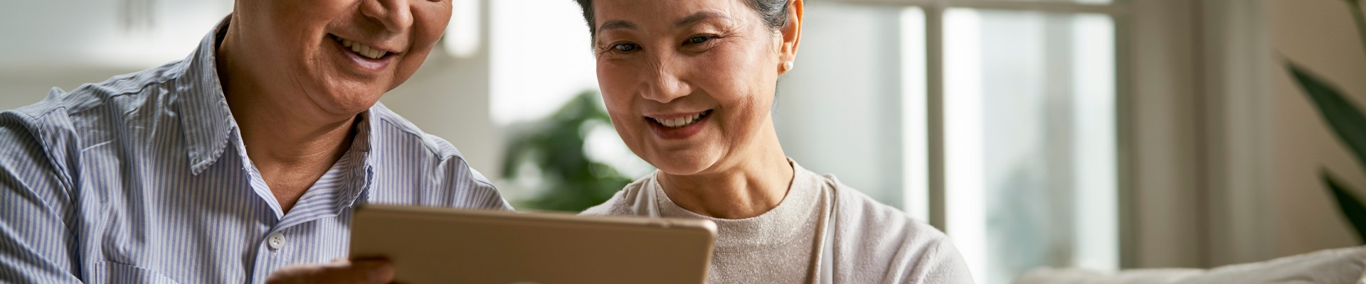 2 personnes âgées regardent une tablette