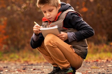 enfant qui note quelque chose dans la nature
