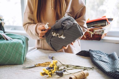 cadeau emballé avec du tissu dans les mains d'une femme