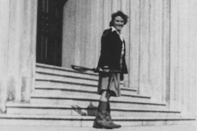 Photographie en noir et blanc d'une femme se tenant debout sur des escaliers