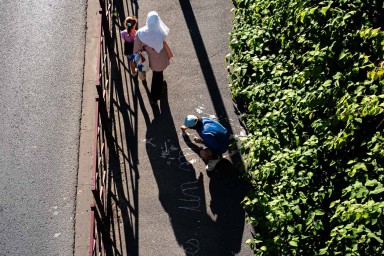 Vue aérienne de l'artiste Malo Patron écrivant sur un trottoir ses textes sur la Bièvre
