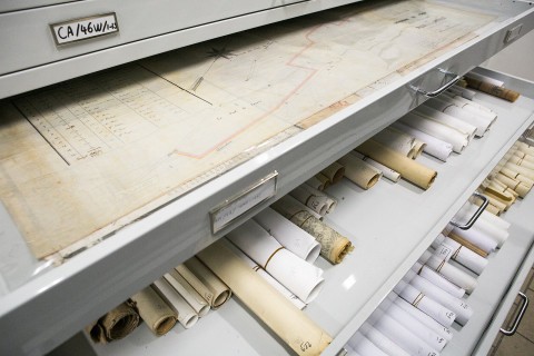 Cartes et rouleaux de documents anciens rangés dans des tiroirs