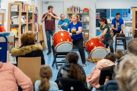 vue intérieure lors d'un spectacle de tambours japonais au milieu des livres avec du public