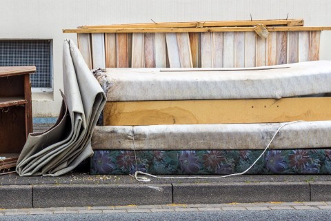 Matelas et morceaux de meubles sur le trottoir