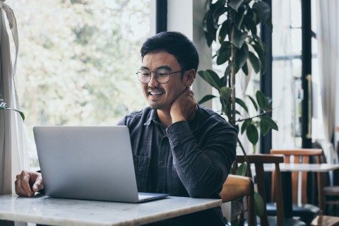 Une personne sourit en regardant l'écran de son portable