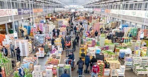 Plan large intérieur halles Rungis avec cagettes de fruits et légumes formant des allées - Agrandir l'image, fenêtre modale