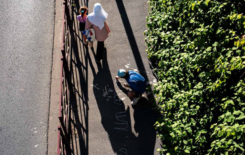Vue aérienne de l'artiste Malo Patron écrivant sur un trottoir ses textes sur la Bièvre